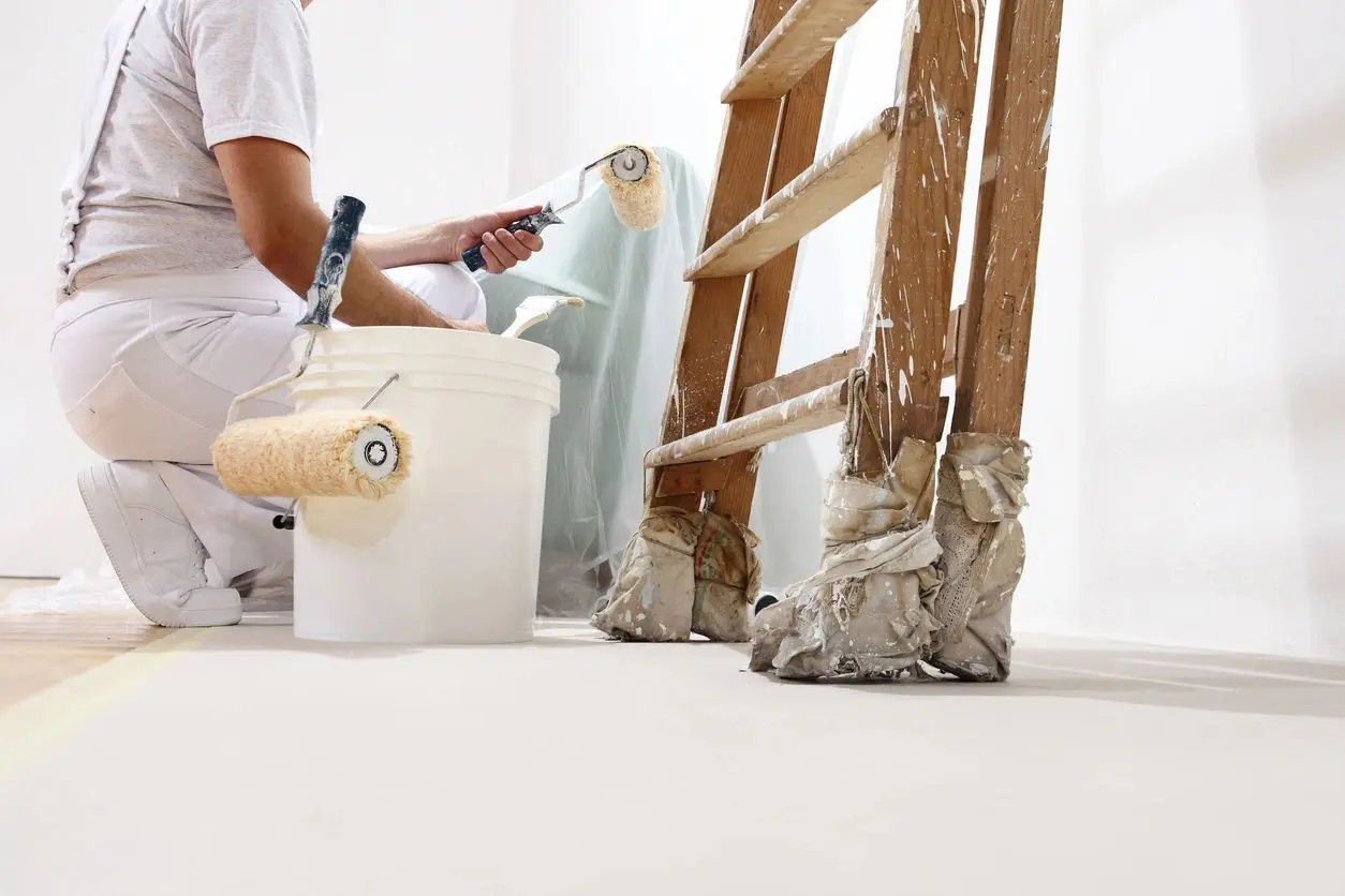 A man is painting the floor of his home.